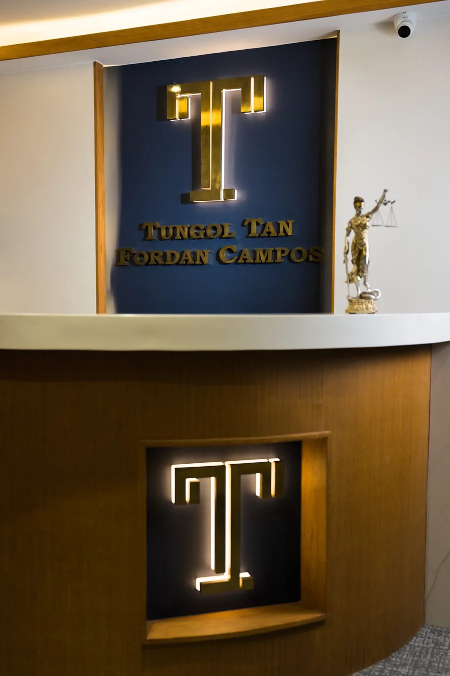 The TTFC Law reception: the lit brass T and the firm's name above the front desk